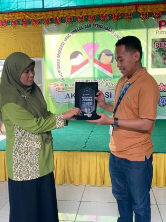 KOORDINATOR Ruang Guru Sulteng, Irfan saat menyerahkan piala penghargaan kepada Wakil Ketua Yayasan Pendidikan Putra Kaili Permata Bangsa, Bidang Humas, Iriyanti. Selasa (14/2/2023). FOTO: IST