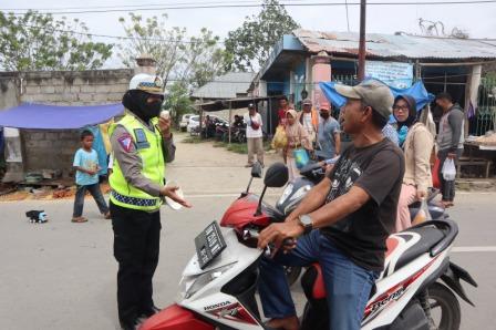 Personel Satgas Ops Keselamatan Tinombala 2023 Polda Sulteng saat melakukan sosialisasi dan edukasi disiplin berlalulintas kepada seorang pengendara yang melintas di Pasar Tradisional di Kelurahan Lasoani, kota Palu, Rabu (8/2/2023). FOTO: DOK DITLANTAS POLDA SULTENG