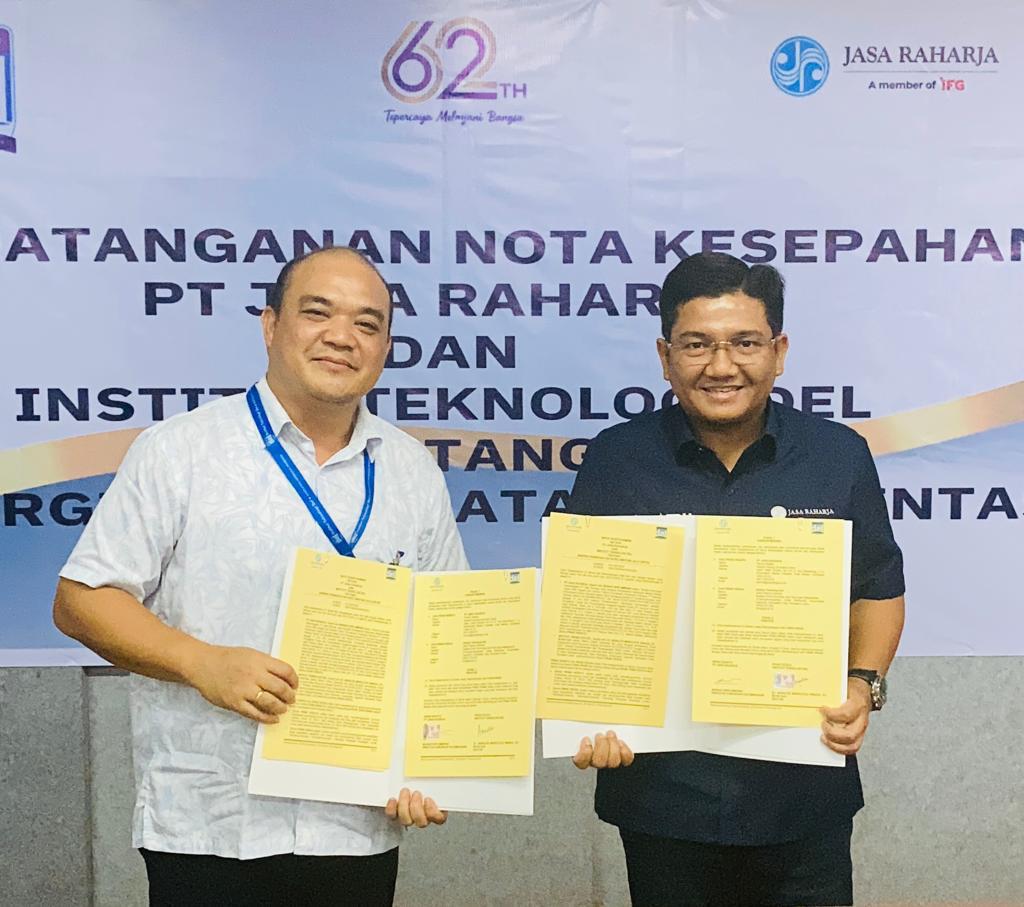 Direktur Hubungan Kelembagaan Jasa Raharja Munadi Herlambang dan Rektor Institut Teknologi Del, Dr. Arnaldo Marulitua Sinaga, ST., M.InfoTech, memperlihatkan berkas MoU yang telah mereka tandatangani berdua, Rabu (8/2/2023). Foto: Humas