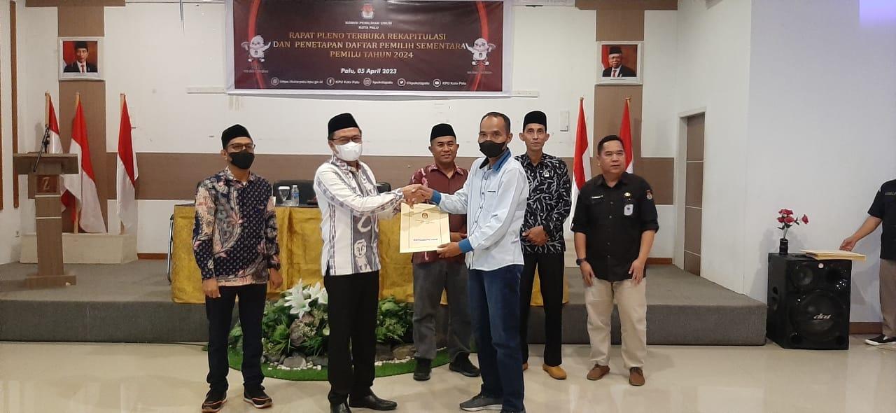 Ketua KPU Kota Palu, Agussalim Wahid menyerahkan dokumen yang berisi Daftar Pemilih Sementara kepada salah satu perwakilan partai politik, Rabu (5/4/2023). Foto: IST