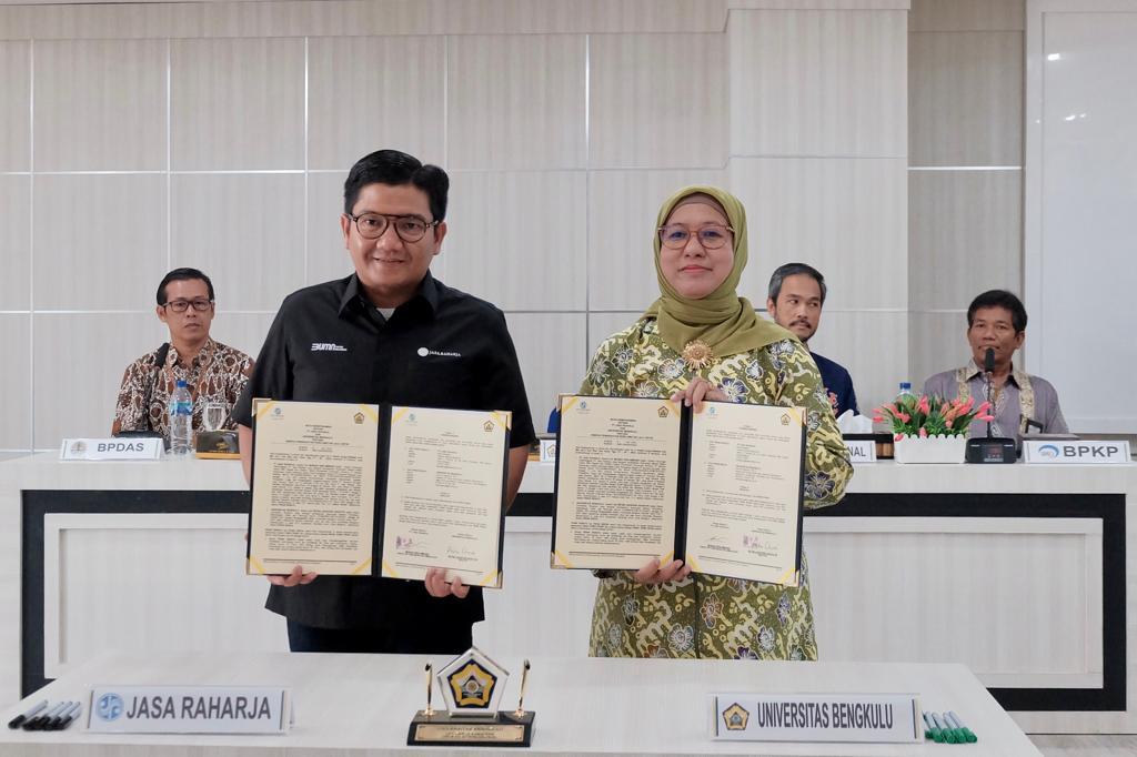 Direktur Hubungan Kelembagaan Jasa Raharja Munadi Herlambang dan Rektor Universitas Bengkulu, Dr. Retno Agustina Ekaputri, S.E., M.Sc, memperlihatkan berkas MoU yang telah mereka tandatangani, Kamis (11/05/2023). Foto: Humas