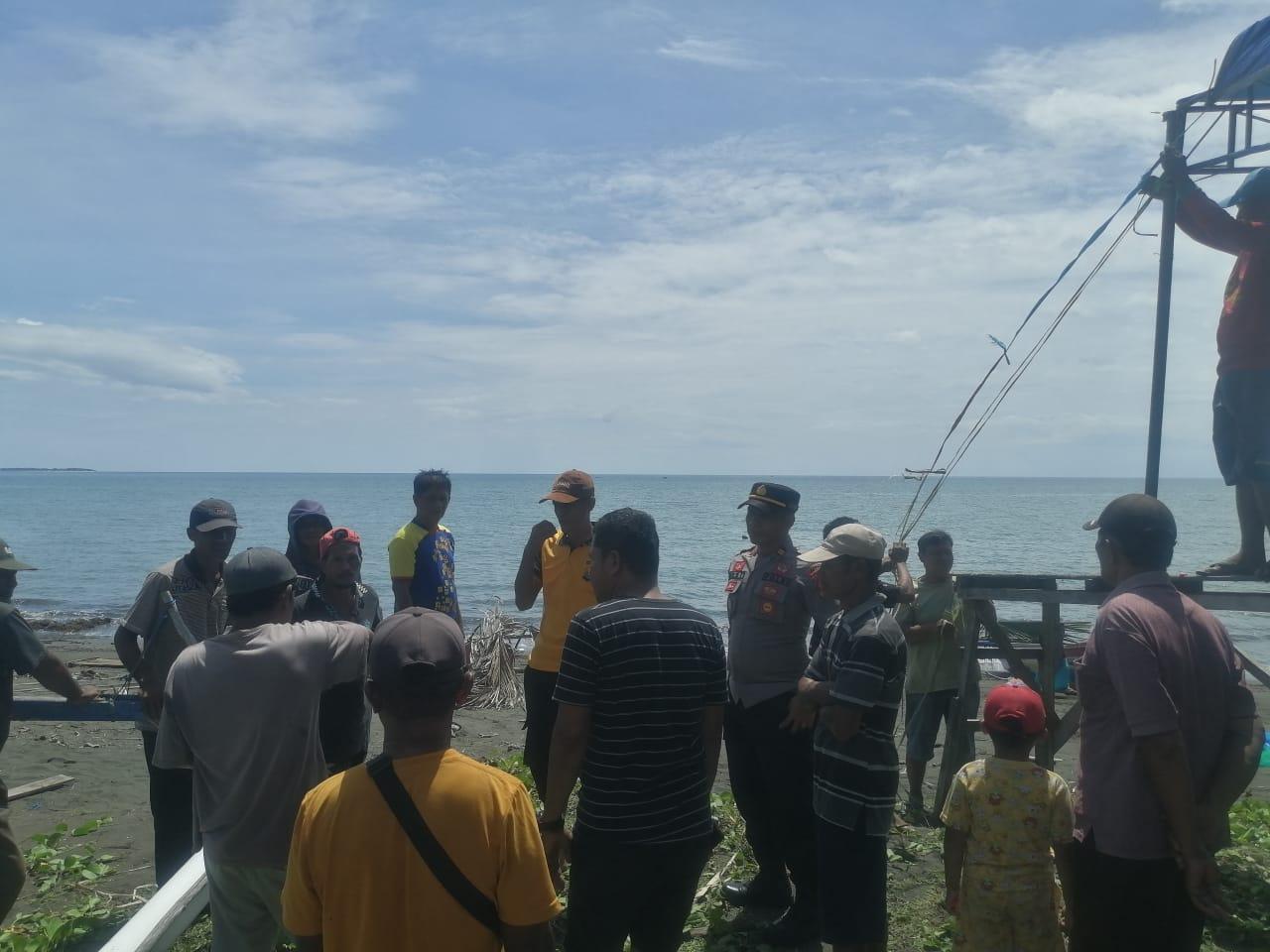 Sejumlah warga di Desa Bualemo berkumpul di pinggir laut untuk mencari nelayan yang hilang, Sabtu (15/7/2023). FOTO: DOK POLSEK BUALEMO