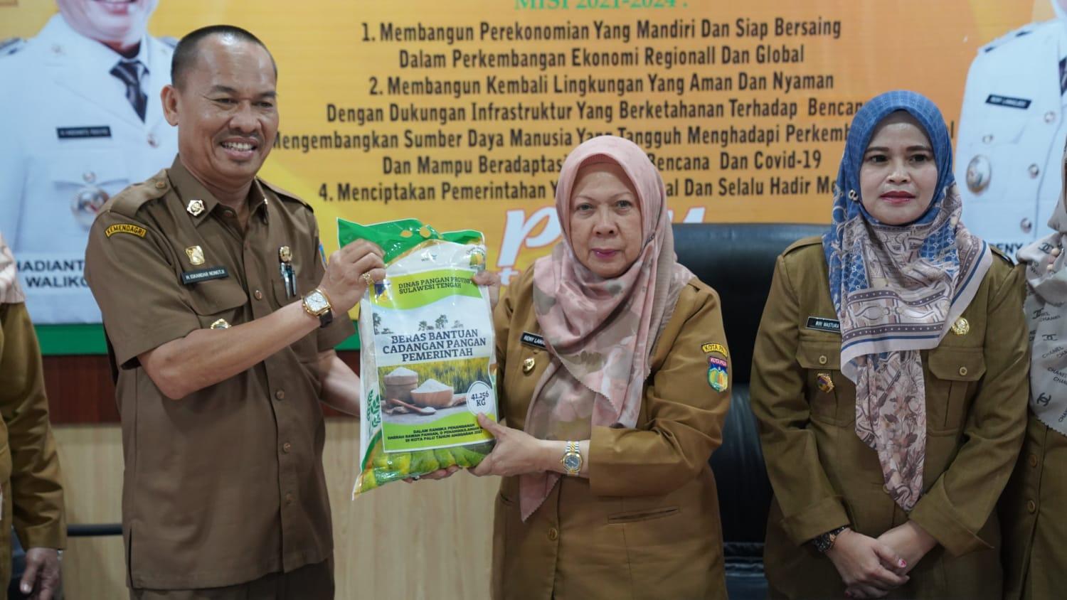 FOTO: Kadis Pangan Sulteng, Iskandar Nongtji, menyerahkan secara simbolis bantuan cadangan pangan berupa beras kepada Wawali Palu, dr Reny A Lamadjido, didampingi Kadis Pangan dan Hortikultura Palu, Asharini Mastura di Kantor Wali Kota Palu, Selasa (5/9/2023). FOTO: IST