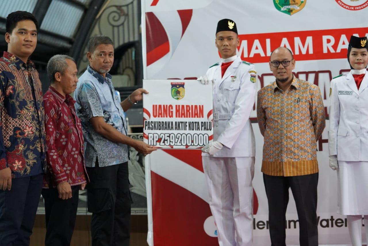 FOTO: Asisten Bidang Pemerintahan dan Kesra Setda Kota Palu, Muhammad Rizal, didampingi Kaban Kesbangpol Kota Palu, Ansyar Sutiadi, menyerahkan secara simbolis uang harian Paskibraka aktif Kota Palu sebesar Rp259 juta kepada anggota Paskibraka Kota Palu saat malam ramah tamah bersama Paskibraka Kota Palu 2023 di salah satu tempat taman bermain air di Kota Palu, Sabtu (9/9/2023). FOTO: IST