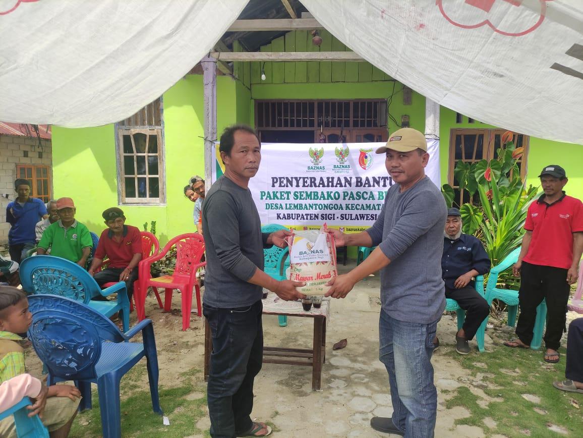 Ketua BAZNAS Kabupaten Sigi Hadi Wijaya saat menyerahkan secara simbolis bantuan sembako kepada masyarakat Desa Lembantongoa yang diterima langsung oleh Sekdes Lembantongoa Ahmad Rifai, Ahad (10/9/2022). FOTO:FERRY