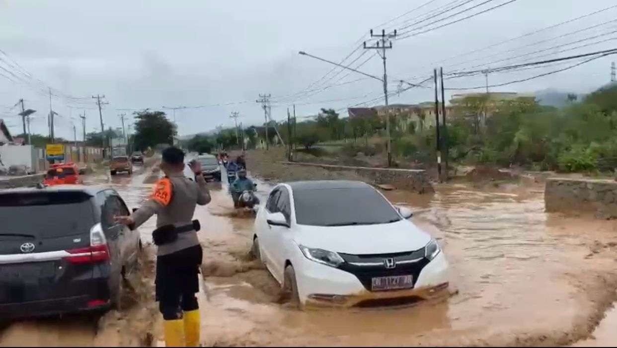 Personel Ditsamapta Polda Sulteng saat mengatur laulintas di Jalan Soekarno Hatta karena terdapat genangan air yang bercampur lumpur akibat hujan, Rabu (24/1/2024) pagi. FOTO: BIDHUMAS POLDA SULTENG