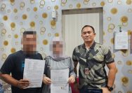 Pasangan suami istri berinisial DAG (33) dan HM, warga Kelurahan Bungin Timur, Kecamatan Luwuk, berpose bersama memperlihatkan surat pernyataan untuk berdamai di ruangan PPA Satreskrim, Ahad (28/1/2024). FOTO: DOK POLRES BANGGAI